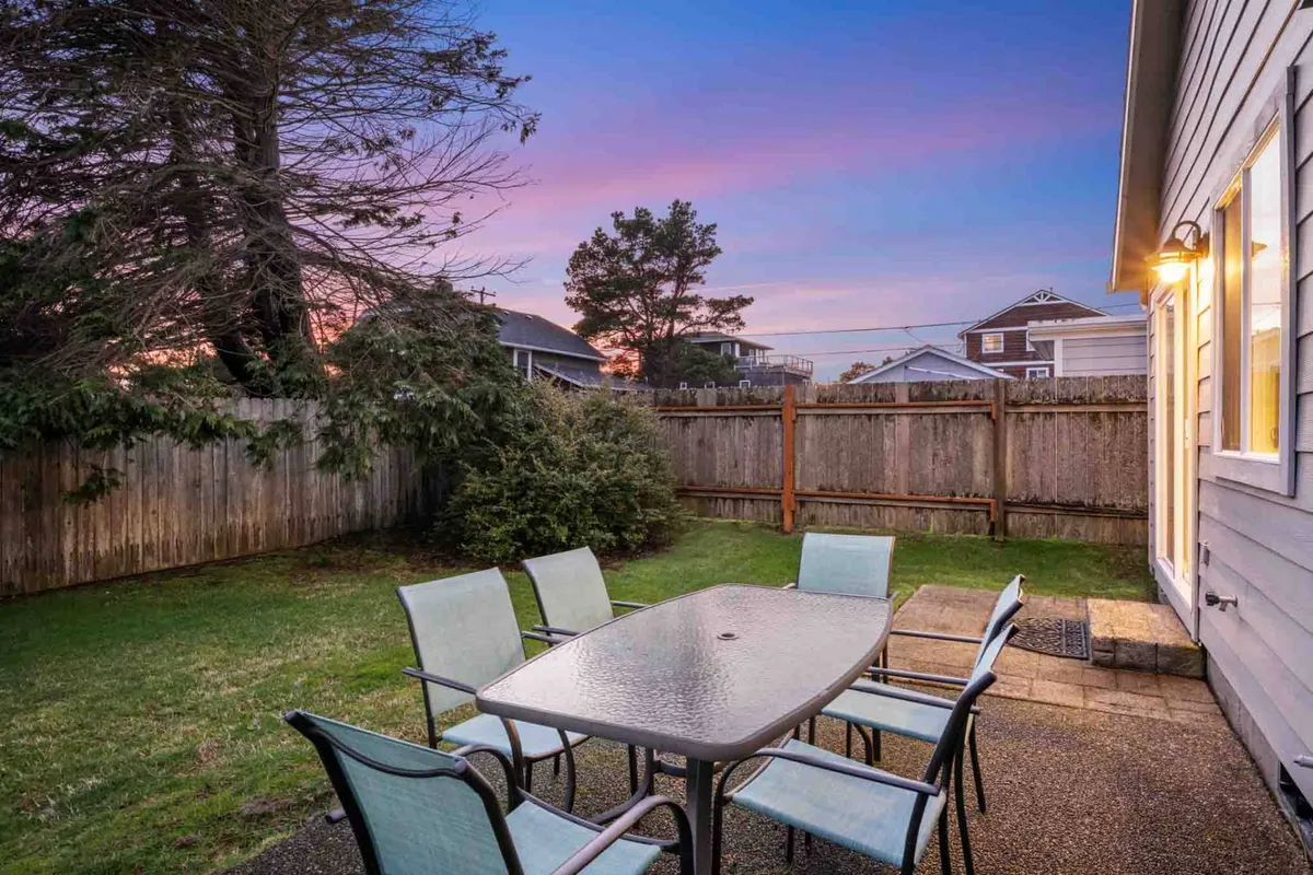 An inviting outdoor dining area overlooks a beautiful sunset sky, with a table and chairs arranged for gatherings or quiet contemplation. The ambiance is relaxed and ideal for unwinding after a productive day.