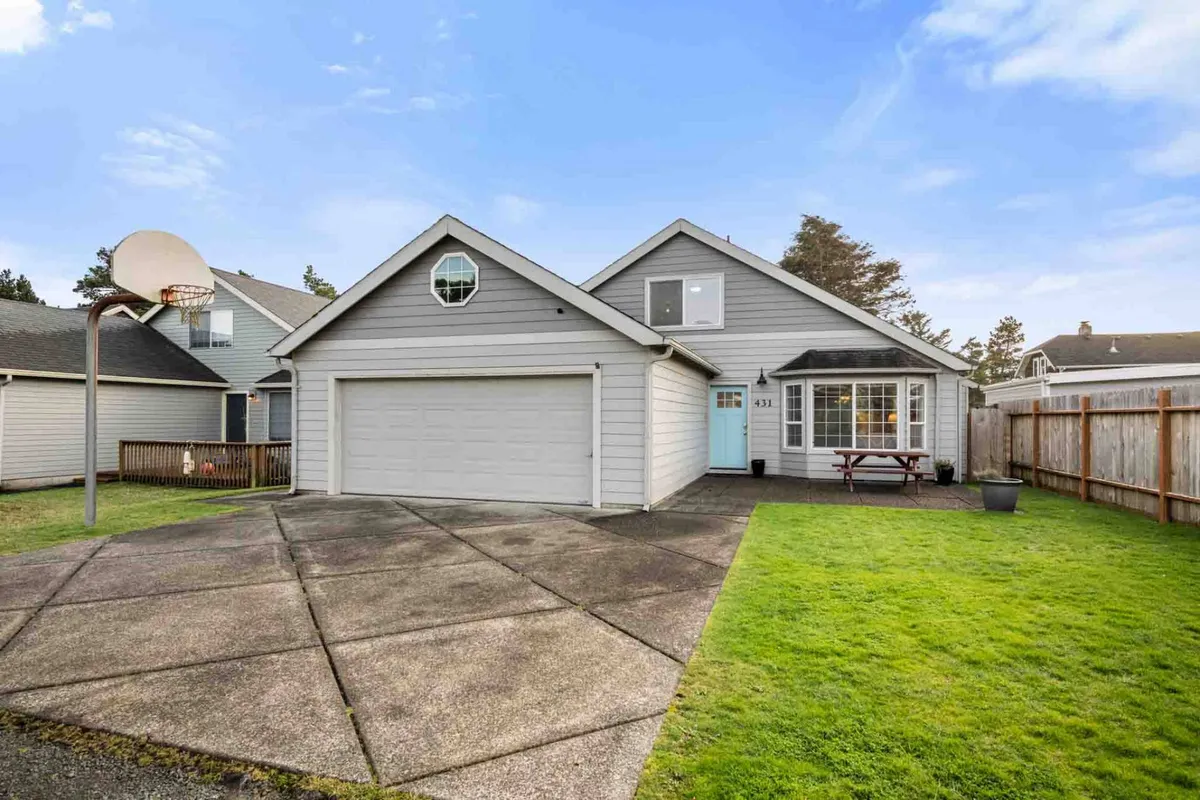 A playful view of the front of the house, featuring a prominent basketball hoop above the driveway, neatly mowed lawn, and the garage. The setup invites friendly games and outdoor activities right at the doorstep.