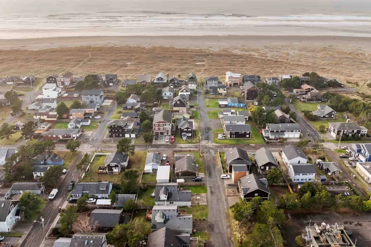 A peaceful beach scene with houses and roadways just steps from the sand, perfect for family walks, beachcombing, and gathering together at the shore.